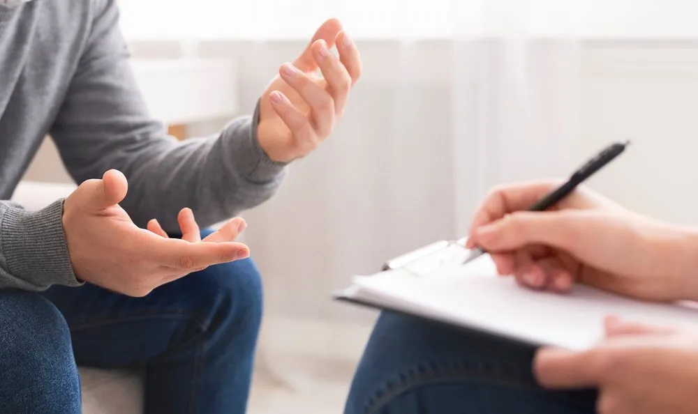 A counsellor taking notes during a session