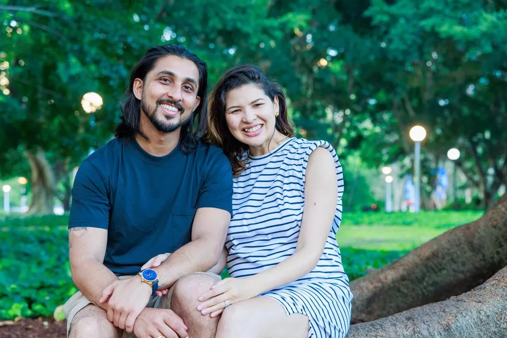 A smiling couple sitting together in a park